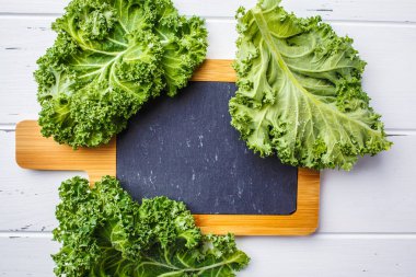 Yeşil salata lahana Beyaz ahşap arka plan ve metin, kopya alanı, en iyi görünüm için kayrak bir tahta üzerinde yapraklar.
