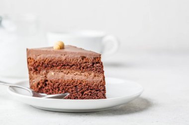 Bir beyaz tabak, beyaz arka plan, kopya alanı çikolatalı kek parçası. Vegan tatlı, bitki esaslı gıda kavramı.