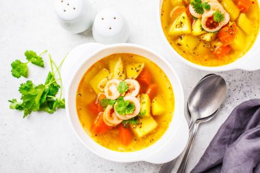 Sosis ve sebze beyaz kase, beyaz arka plan, üstten görünüm ile Alman patates çorbası. Alman mutfağı yemek tarifleri.