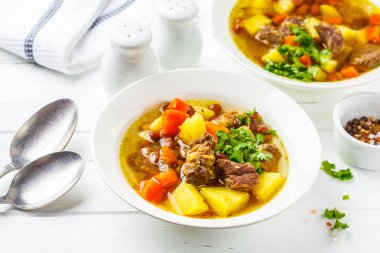 Geleneksel Alman eintopf çorba, et, fasulye ve beyaz bir tabakta sebze.