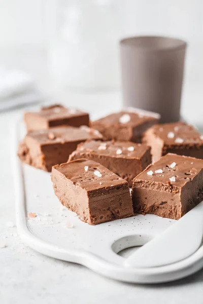 Raw vegan chocolate fudge on a white board. Healthy vegan food concept.