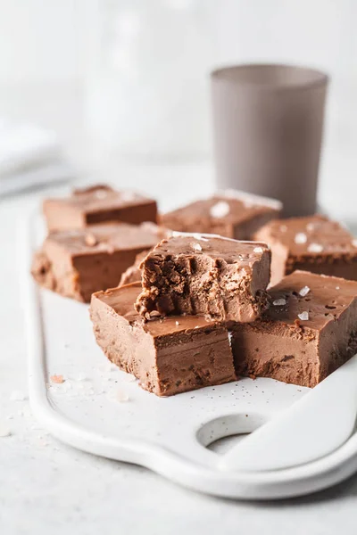 Raw vegan chocolate fudge on a white board. Healthy vegan food concept.