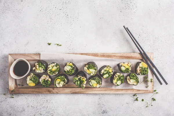 纯素绿色寿司卷与鳄梨 黄瓜和紫藤在木板上 灰色的背景 — 图库照片