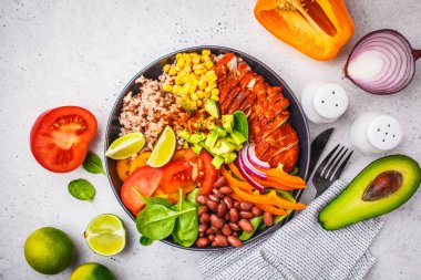Meksika tavuk dürüm kase pirinç, fasulye, domates, avokado, Mısır ve ıspanak, beyaz arka plan ile. Meksika mutfağı gıda kavramı.