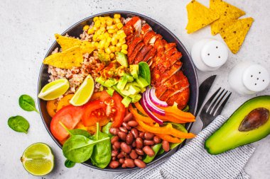 Meksika tavuk dürüm kase pirinç, fasulye, domates, avokado, Mısır ve ıspanak, beyaz arka plan ile. Meksika mutfağı gıda kavramı.