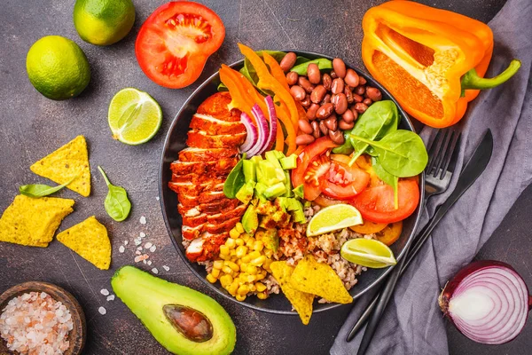 Pirinç, fasulye, domates, avokado, Mısır ve ıspanak, koyu arka plan, üstten görünüm ile Meksika tavuk dürüm kase. Meksika mutfağı gıda kavramı.