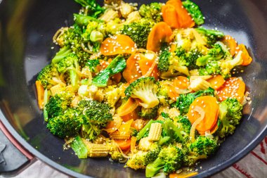 Vegan wok stir fry brokoli ve havuç, karanlık backgrond ile.