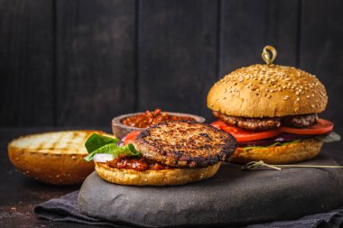 İle et ve sebze karanlık bir arka plan üzerinde açık ev yapımı Hamburger.
