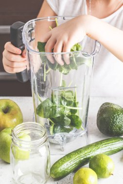 Mutfakta yeşil smoothie hazırlık. Çocuk yemek ıspanak elma salatalık güler yüzlü. Sağlıklı bitki esaslı gıda.