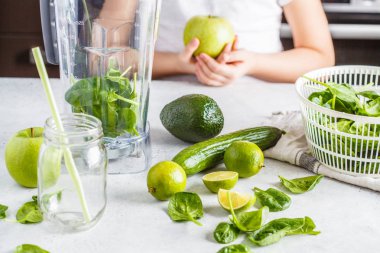 Mutfakta yeşil smoothie hazırlık. Çocuk yemek ıspanak elma salatalık güler yüzlü. Sağlıklı bitki esaslı gıda.