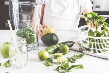 Mutfakta yeşil smoothie hazırlık. Çocuk yemek ıspanak elma salatalık güler yüzlü. Sağlıklı bitki esaslı gıda.