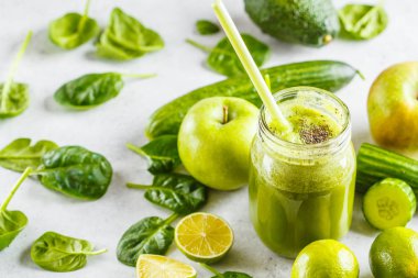 Yeşil sağlıklı güler yüzlü (suyu) kavanozun içinde. Apple, ıspanak, salatalık smoothie malzemeler ile beyaz bir arka plan üzerinde.
