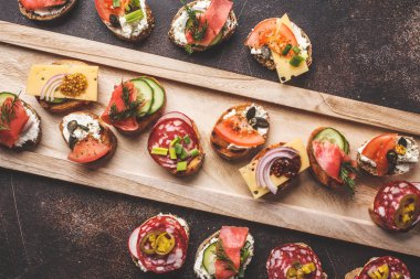 Balık, sosis, peynir ve sebze çeşitli İspanyolca tapas. Koyu arka plan, düz yatıyordu.