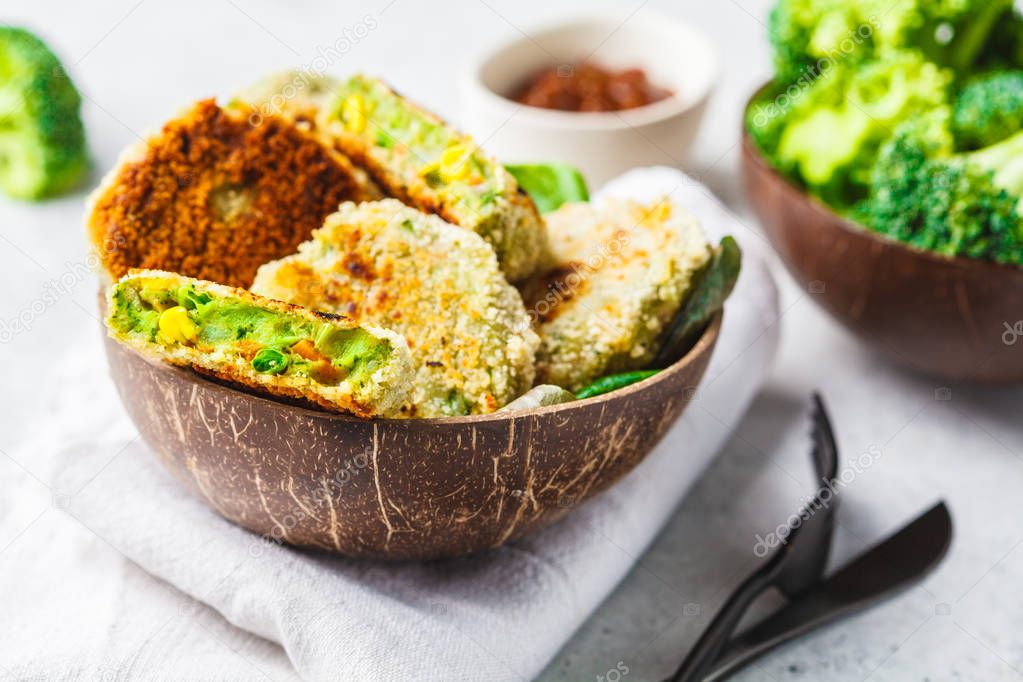 Green broccoli burgers in coconut shell dish on white background. Healthy vegn food concept.