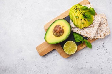 Ahşap masa, beyaz arka plan üzerinde bütün tahıl ekmeği ile avokado tost.