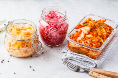 Korean kimchi cabbage, beet sauerkraut and sauerkraut in glass jars, white background. Probiotics food concept. clipart