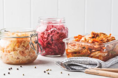 Korean kimchi cabbage, beet sauerkraut and sauerkraut in glass jars, white background. Probiotics food concept. clipart