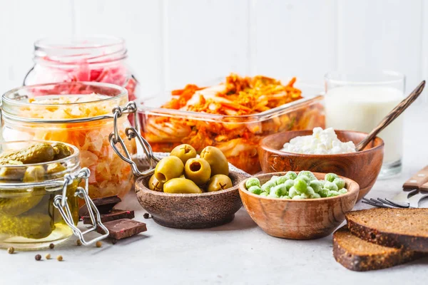 Probiyotik gıda arka plan. Kimchi, pancar lahana, lahana turşusu, süzme peynir, zeytin, ekmek, çikolata, kefir ve salatalık turşusu cam kavanozlar, beyaz arka plan.