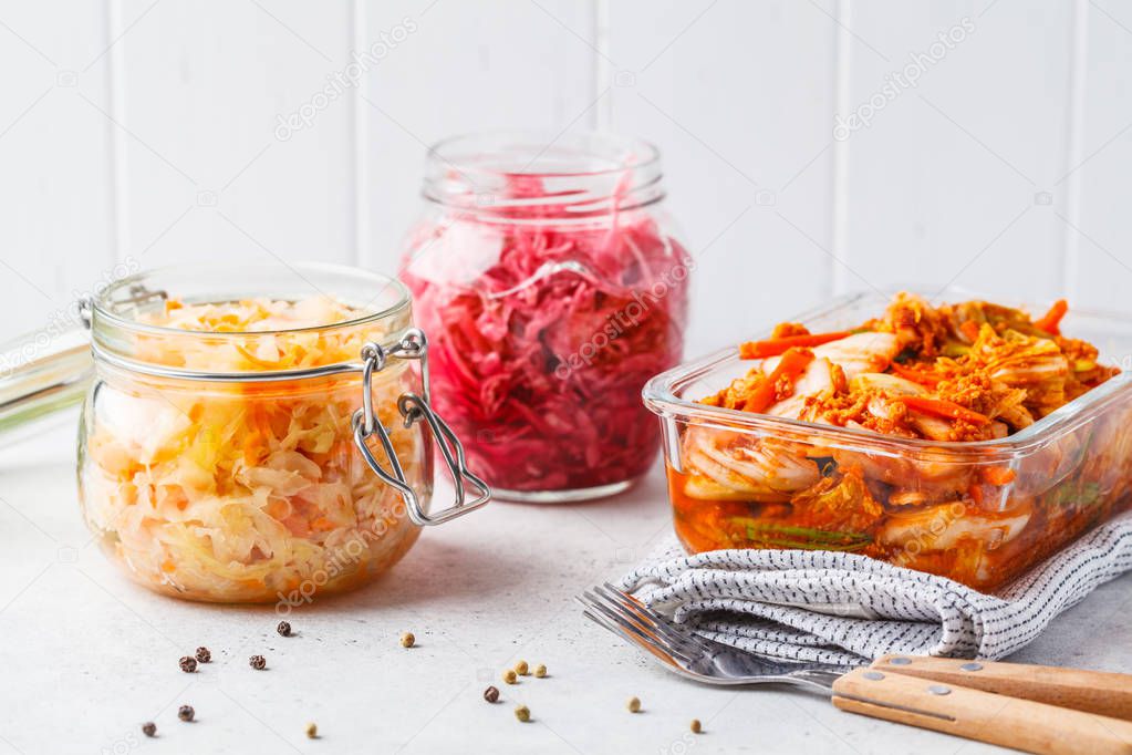 Korean kimchi cabbage, beet sauerkraut and sauerkraut in glass jars, white background. Probiotics food concept.