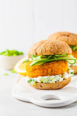 Salatalık, roka ve mayonez sos, beyaz arka plan, vejetaryen yemek balık burger.