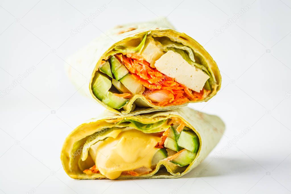 Vegan tofu wraps with cashew cheese sauce and vegetables, white background. Plant based food concept.