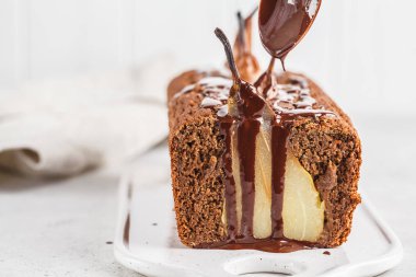 Çikolata armut pasta beyaz tahta üzerinde.