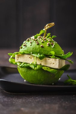 Siyah çanak vegan avokado tofu burger. Sağlıklı Detoks gıda, pla