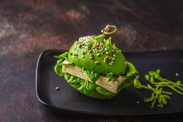 stock image Vegan avocado tofu burger on black dish. Healthy detox food, pla