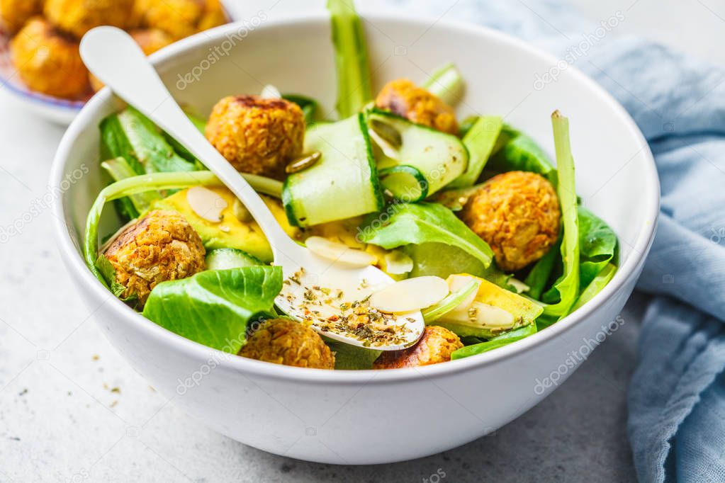 Vegan salad with beans meatballs, avocado and cucumber in white 