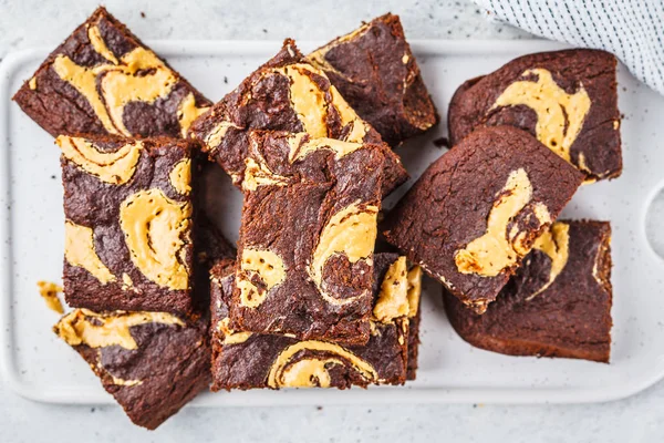 Vegan brownie with peanut butter on white background.