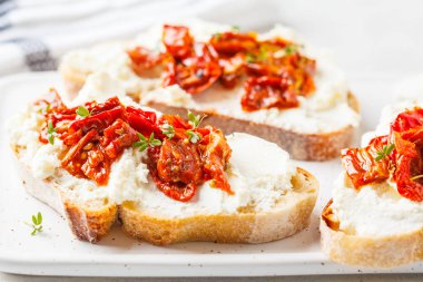 Ricotta ve güneş domates sandviç beyaz tahta üzerinde kurutulmuş.