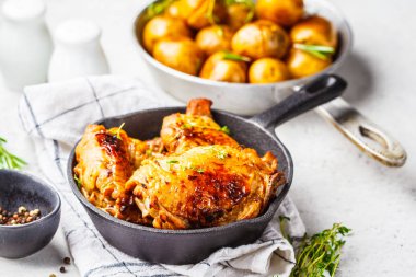 Dökme demir tavada ızgara tavuk ve fırında patates.