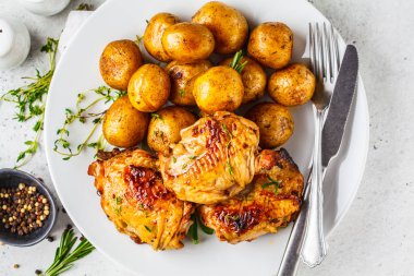 Dökme demir tavada ızgara tavuk ve fırında patates.