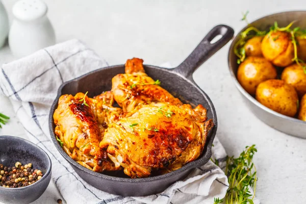 Pollo a la parrilla y patatas al horno en una sartén de hierro fundido . —  Fotos de Stock