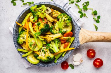 Tavada kızarmış brokoli, biber, mısır, kabak ve domates 