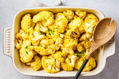 Beyaz beton arka plan üzerinde fırın çanak pişmiş karnabahar.