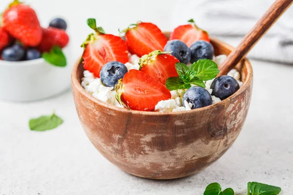 Cottage cheese with strawberries and blueberries in wooden bowl — Stock Photo, Image