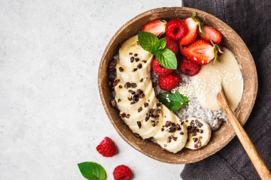 Çilek, muz, fıstık ezmesi ve kakao uçları ile Chia puding 