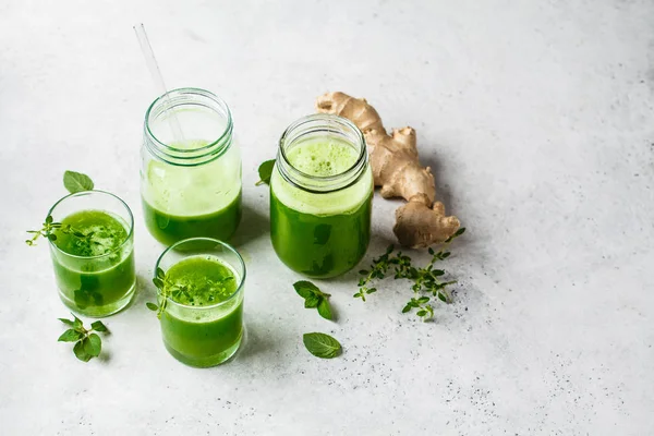 Succo verde di disintossicazione con zenzero e menta in bicchieri e barattoli . — Foto Stock