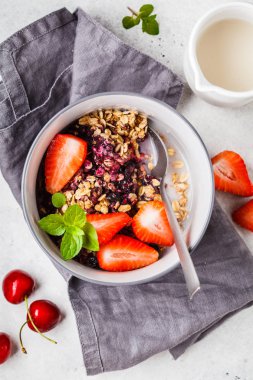 Gri bir kase, üst görünüm çilek ve süt ile pişmiş yulaf ezmesi. 