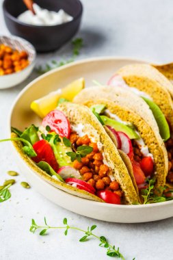 Pişmiş nohut, avokado, sos ve sebzeli Vegan taco 'lar 