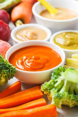 Malzemelerle beyaz kaselerde sebze ve meyve bebek püresi. 