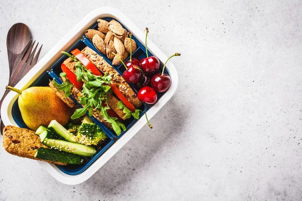 Lunch låda med smörgås, päron, grönsaker, nötter och tilltugg — Stockfoto