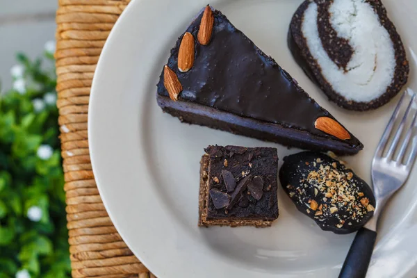 Various vegan desserts on a plate, outside in a cafe.