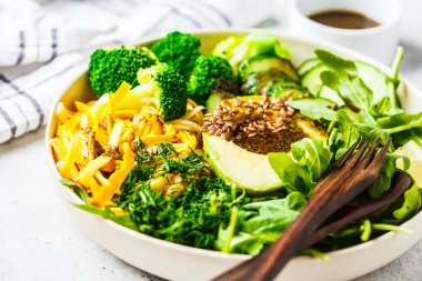 Brokoli, kabak makarna, avokado ve giyinme ile yeşil salata.