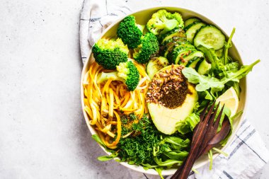 Brokoli, kabak makarna, avokado ve giyinme ile yeşil salata.