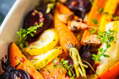 Fırında kekik ile pişmiş sebzeler, mavi arka plan.