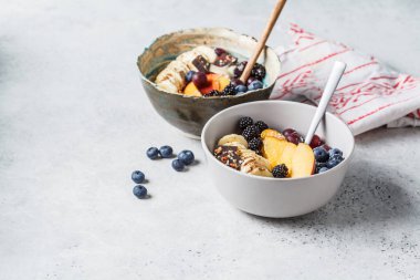 Muz, şeftali, çilek ve kaselerde superfoods ile yulaf ezmesi.