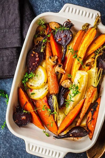 Horneado verduras con tomillo en el plato del horno, fondo azul . — Foto de Stock