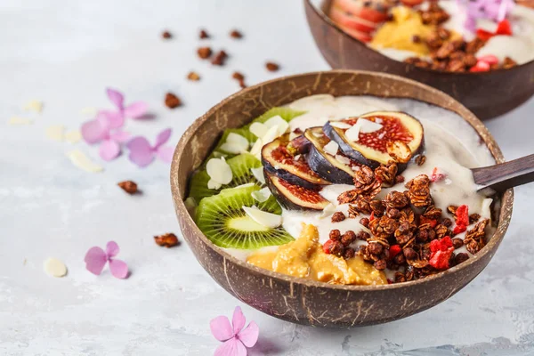 Smoothie bowl with fruit and granola with coconut shell bowl